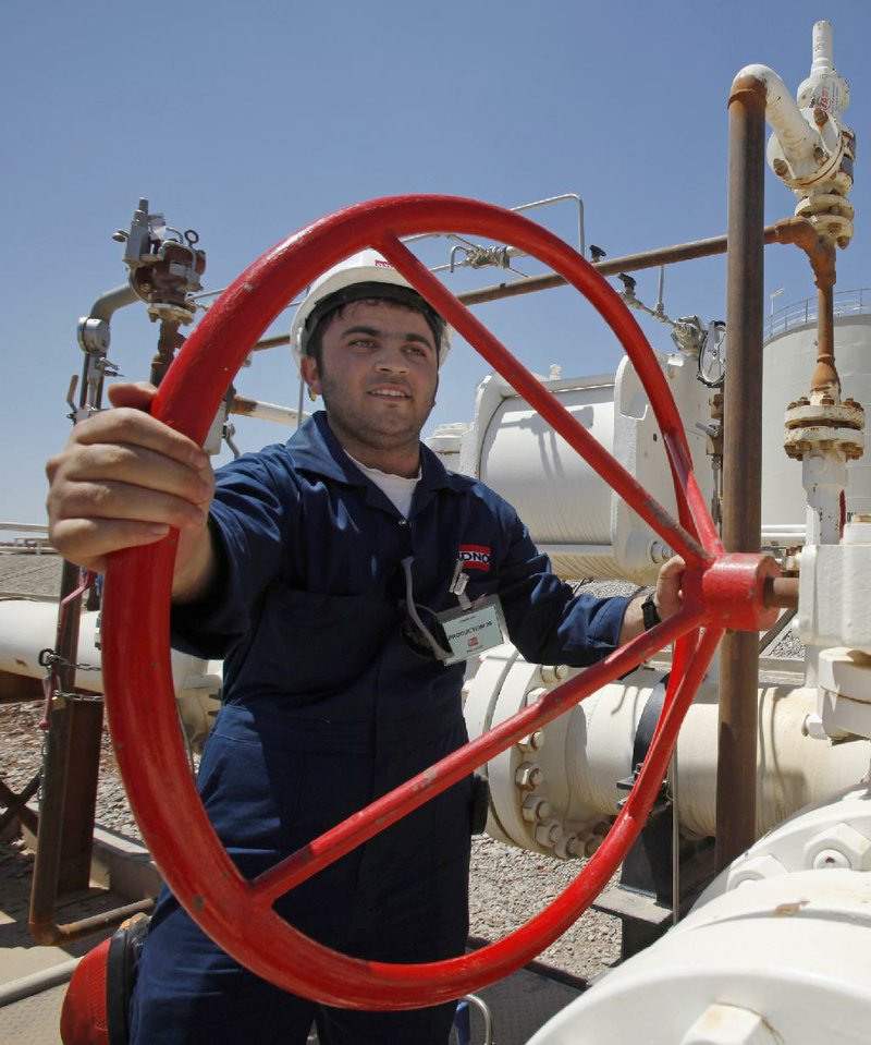 FILE - In this May 31, 2009 file photo, an employee works at the Tawke oil fields in the semiautonomous Kurdish region in northern Iraq. Iraq's self-ruled northern Kurdish region said Friday that it has made its first oil shipment through its own pipeline to the international market, bypassing the central government in Baghdad, which insists that it has the sole right to develop and market the country's natural resources. (AP Photo/Hadi Mizban, File)