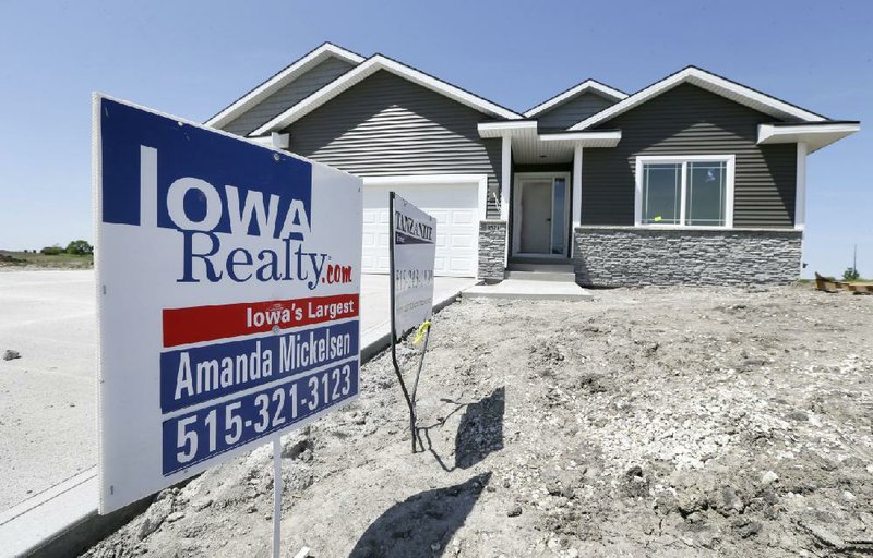 In this May 21, 2014 photo, a sign sits in front of a new home for sale in West Des Moines, Iowa.  The Commerce Department reports on sales of new homes in April on Friday, May 23, 2014. (AP Photo/Charlie Neibergall)