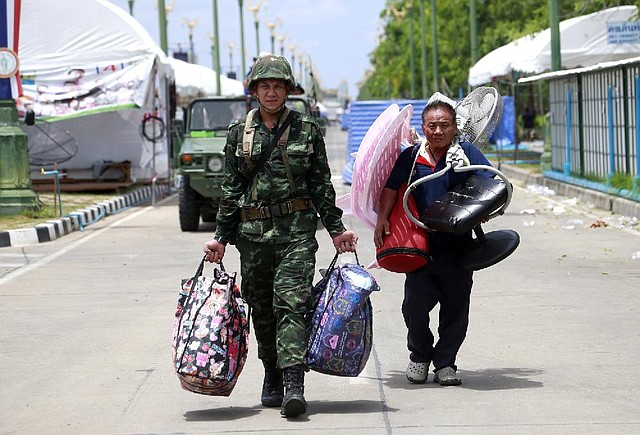 A Thai soldier escorts a protester away from a demonstration site Friday in Bangkok as large gatherings were under a ban by the military government. 