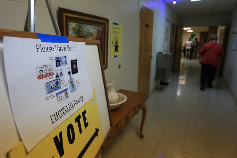 A sign at Woodlawn Baptist Church in Little Rock on Tuesday reminded voters that a photo ID is required to cast ballots. 