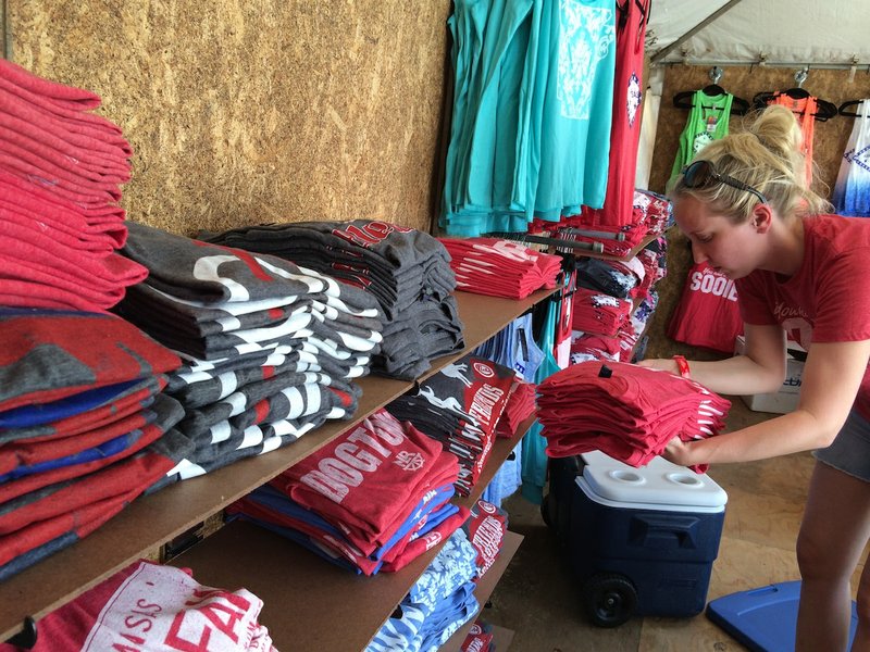 Casey Jordan stacks shirts in the Stated Apparel booth at Riverfest on Friday. The annual festival begins at 6 p.m. and lasts through Sunday evening. 