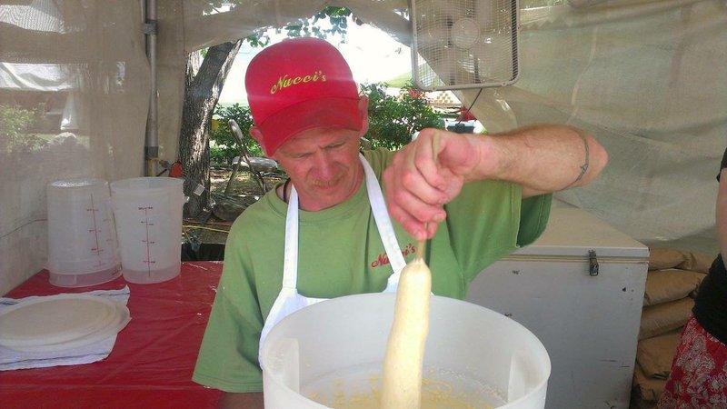 Robert Mitchell, who has worked for Nucci's Concessions for over 20 years, prepares a corn dog for Riverfest patrons on Saturday. The annual festival continues through Monday night. 