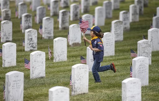Cub Scout Mateo Armijo, 7, with Pack 28 in Burlingame, runs with flags at the Golden Gate National Cemetery in San Bruno, Calif., on Saturday, May 24, 2014. Thousands of Boy Scouts, Cub Scouts, and Girl Scouts took part in the annual event to place 117,000 tiny flags on the graves.