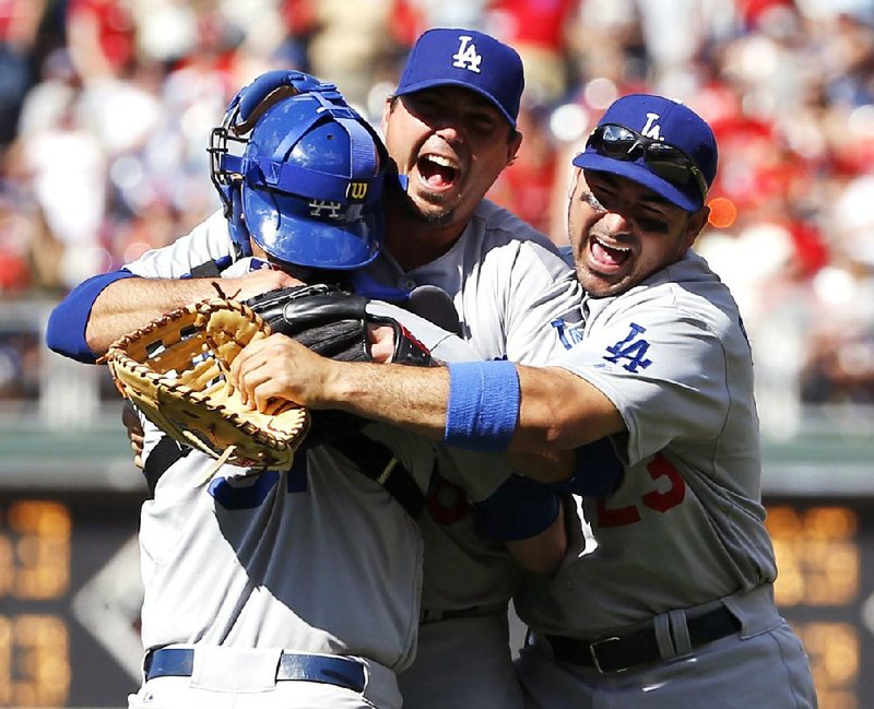 Los Angeles Dodgers starting pitcher Josh Beckett, center, celebrates with catcher Drew Butera, left, and first baseman Adrian Gonzalez after pitching a no-hitter baseball game against the Philadelphia Phillies, Sunday, May 25, 2014, in Philadelphia. Los Angeles won 6-0. Beckett pitched the first no-hitter of his career and the first in the majors this season. (AP Photo/Matt Slocum)