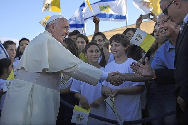 Pope Francis greets Israeli children after at the heliport of Hadassah hospital in mount Scopus Jerusalem, Sunday, May 25, 2014. Pope Francis took a dramatic plunge Sunday into Mideast politics while on his Holy Land pilgrimage, receiving an acceptance from the Israeli and Palestinian presidents to visit him at the Vatican next month to discuss embattled peace efforts. The summit was an important moral victory for the pope, who is named after the peace-loving Francis of Assisi.  (AP Photo/Tsafrir Abayov)