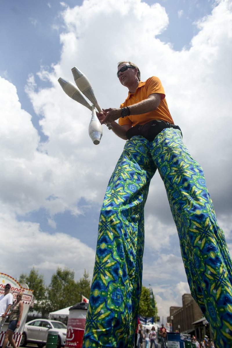 Arkansas Democrat-Gazette/MELISSA SUE GERRITS - 05/25/2014 - Variety performer Mark Lippard performs in the midway during Riverfest May 25, 2014. "I'm still learning!", announced Lippard who specializes in juggling, unicycling, balloon sculpting, stilt walking, and even fire-eating. 