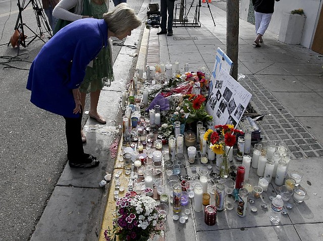 Rep. Lois Capps, D-Santa Barbara, pays her respects at a makeshift memorial in front of the IV Deli Mart, where part of Friday night's mass shooting took place by a drive-by shooter Sunday, May 25, 2014 in the Isla Vista area near Goleta, Calif. Calif. Sheriff's officials said Elliot Rodger, 22, went on a rampage near the University of California, Santa Barbara, stabbing three people to death at his apartment before shooting and killing three more in a crime spree through a nearby neighborhood. (AP Photo/Chris Carlson)