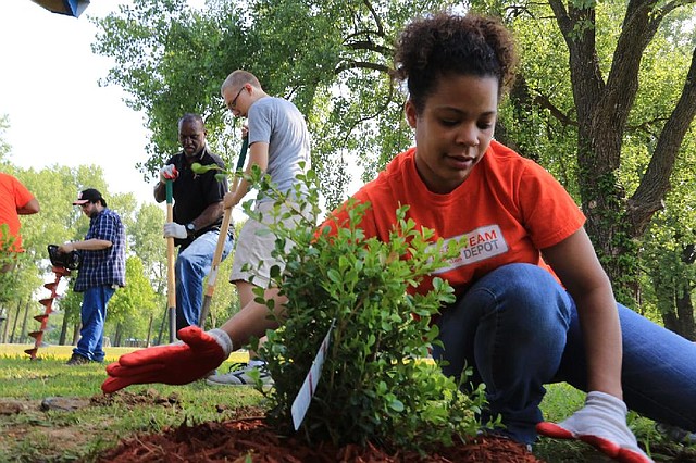 Arkansas Democrat-Gazette/RICK MCFARLAND --05/20/14--  Samantha Nelson smoothes the mulch around a plant as Zach Baxla ( right,center) and Freddie Mable use shovels to dig a hole for a plant near the Wounded Warriors Veteran Pavilion along the Arkansas River Trail in Burns Park Thursday. Baxla came up with the plans for two small pavilions for his Eagle Scout service project. Home Depot 's Team Depot donated supplies and workers to do landscaping for the project.