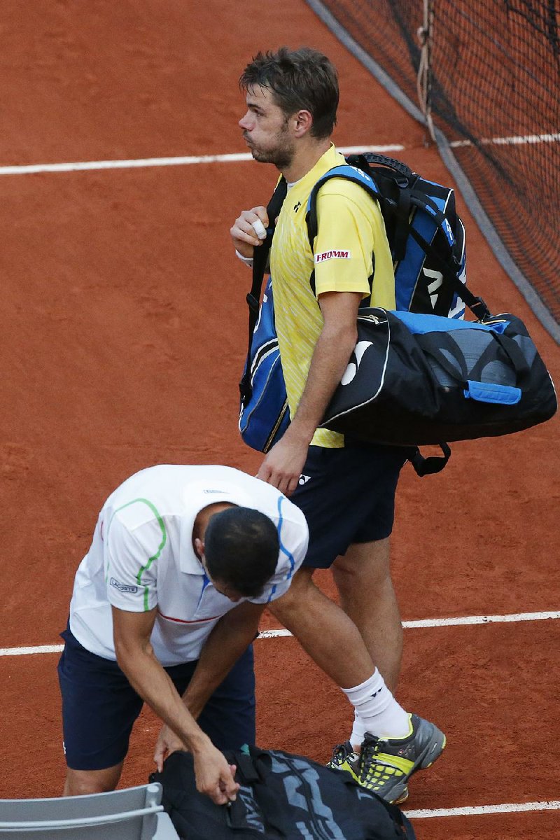 Switzerland's Stanislas Wawrinka, rear, blows out air as he passes Spain's Guillermo Garcia-Lopez, bottom, after losing the first round match of the French Open tennis tournament in four sets at the Roland Garros stadium, in Paris, France, Monday, May 26, 2014. (AP Photo/Michel Euler)