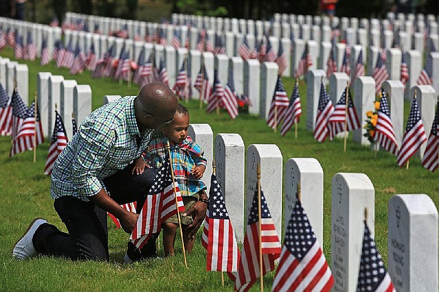 Arkansas Democrat-Gazette/RICK MCFARLAND --05/26/14--  Paul W. Kimbrough, Jr., of Springdale, talks to his son Paul W. Kimbrough III, 18 months, at the grave of Lt. Col. Paul W. Kimbrough, Sr., his father and the boys grandfather after a Memorial Day Ceremony at the Arkansas State Veterans' Cemetery in North Little Rock Monday. The elder Kimbrough died of an illness while serving in Afghanistan on Oct. 3, 2003. He also served in the Persian Gulf and Iraq wars.