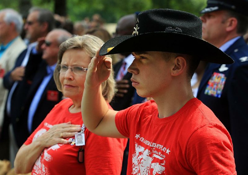 Arkansas Democrat-Gazette/RICK MCFARLAND --05/26/14--  Legend Beck, 19, of Cabot, salutes as the National Anthem is played, while wearing the Calvary Hat of his half brother Cpl. Loren Miles Buffalo, 20, who was killed in the line of duty in Afghanistan on Mar. 9, 2011. Beck and their grandmother Judy Williams were attending a Memorial Day Ceremony at the Arkansas State Veterans' Cemetery in North Little Rock Monday. 