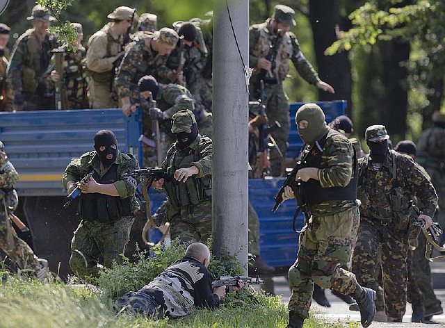 Pro-Russian gunmen take positions near the airport, outside Donetsk, Ukraine, on Monday, May 26, 2014. Ukraine's military launched air strikes Monday against separatists who had taken over the airport in the eastern capital of Donetsk in what appeared to be the most visible operation of the Ukrainian troops since they started a crackdown on insurgents last month. (AP Photo/Vadim Ghirda)