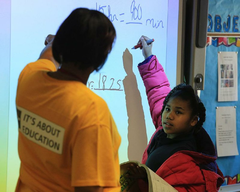 Arkansas Democrat-Gazette/RICK MCFARLAND --02/26/14--   Aniya Fisher listens to her teacher Lolita Hayes (left) while performing a math problem in her 5th grade class at Wilson Elementary School in Little Rock Wednesday. Wilson went from a very low achieving school to a state-identified "exemplary" school in a two year period.