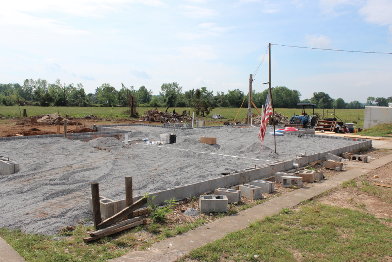 A new cinderblock foundation is set on a home being rebuilt on Cemetery Road after a tornado demolished the previous structure.