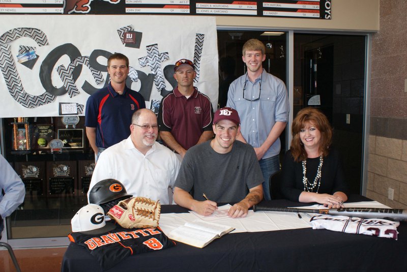 Photo by Dodie Evans Flanked by his parents, Skeeter and Shanna Daniels, Boston Daniels completed signing with Evangel University, Springfield, Mo. In the background, from the left, are Gravette coach Randall Hunt; Lance Quessenberry, head baseball coach at Evangel; and Boston&#8217;s brother, Tanner Daniels.