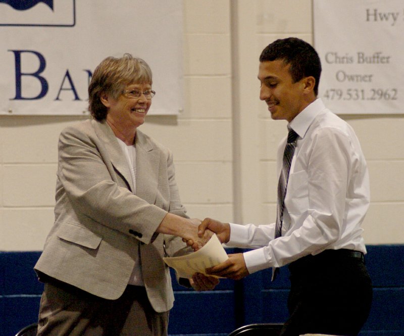 Photo by Mike Eckels Orlando Aquierre-Martinez (right) receives certificate from Nancy Cotter, Decatur high school councilor, for a full scholarship from the University of Arkansas during the May 13 Awards Night at Peterson Gym.