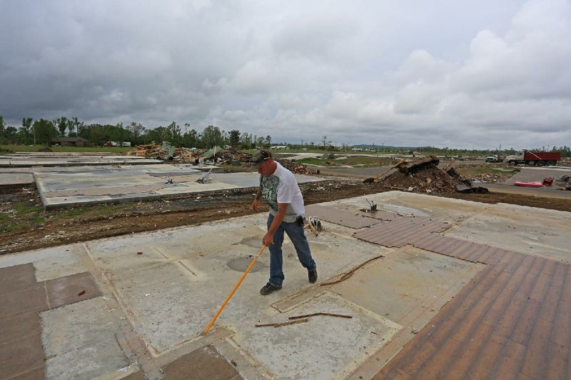 Rodney Langley of Kaplan, La., uses a pry bar Wednesday to remove nails from the slab of a demolished home on Rush Creek Drive in Vilonia, where cleanup from the April 27 tornado continues.