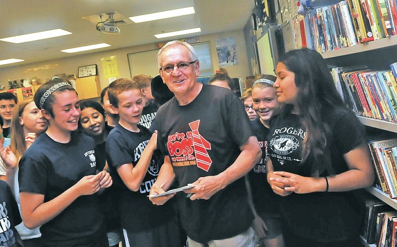 STAFF PHOTO FLIP PUTTHOFF Students at Kirksey Middle school on Wednesday gather around science teacher Don Mallow after Mallow was named teacher of the year in Rogers. Teachers at several Rogers schools received awards and grants Wednesday.