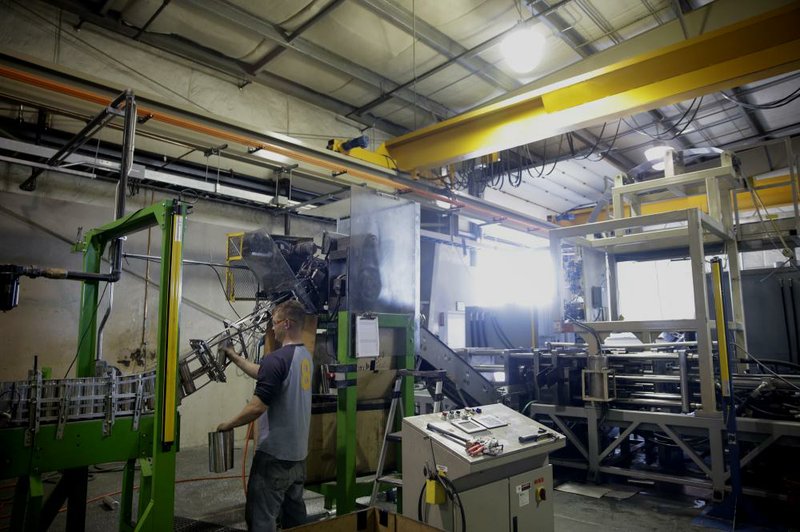 Aluminum water bottles move through the necker stage to create a cylindrical mouth opening during production at the Liberty Bottle Works factory in Union Gap, Wash., on May 20. A harsh winter pushed the U.S. economy into reverse in the January-March quarter, the Commerce Department said Thursday. 