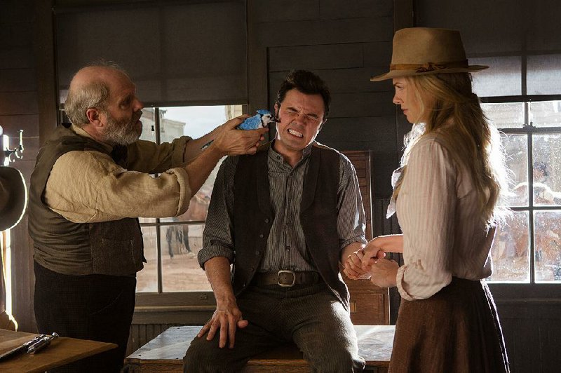 George Stark (Christopher Hagen) administers frontier medicine to his son Albert (Seth MacFarlane) in A Million Ways to Die in the West. 