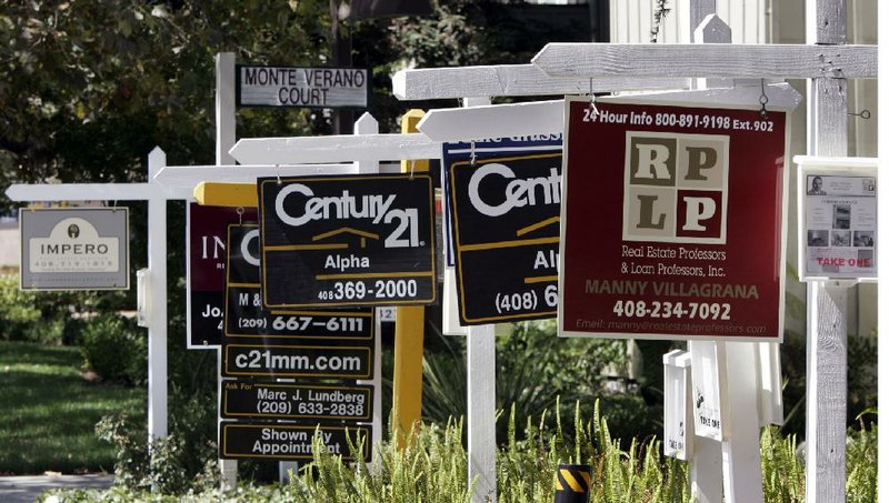 Signs for several homes for sale line a street in San Jose, Calif., in this file photo. The National Association of Realtors said Thursday that contracts to purchase previously owned homes rose in April for a second month in a row. 
