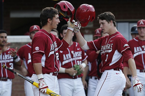 Arkansas infielder Brian Anderson (1) tips his helmet to teammate Eric Fisher (29) after he hit a solo home run in the second inning against Liberty during an NCAA college baseball tournament regional game in Charlottesville, Va., Friday, May 30, 2014. (AP Photo/Steve Helber)