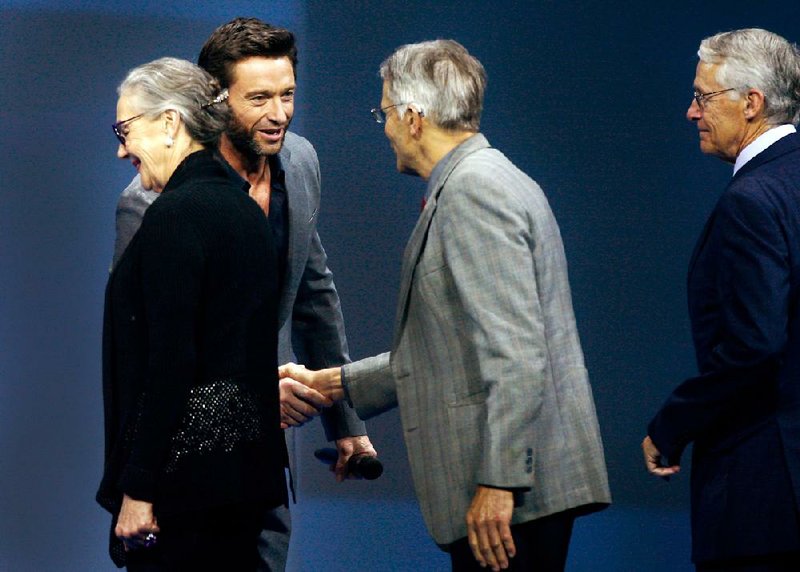 NWA Media/JASON IVESTER
Host Hugh Jackman (second from left) greets Alice Walton, Jim Walton and Rob Walton (right) on stage during the Wal-Mart Shareholders meeting on Friday, June 7, 2013, inside Bud Walton Arena in Fayetteville. Visit photos.nwaonline.com for more photos.