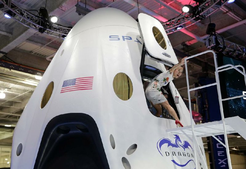 Invited guest Robin Lee walks out of the cabin of the SpaceX Dragon V2 spacecraft at the SpaceX headquarters on Thursday, May 29, 2014, in Hawthorne, Calif. SpaceX, which has flown unmanned cargo capsules to the International Space Station, unveiled the new spacecraft Thursday designed to ferry up to seven astronauts to low-Earth orbit. (AP Photo/Jae C. Hong)