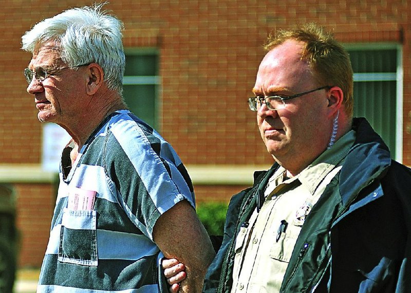 Dr. Paul Becton, left, an obstetrician-gynocologist of Paragould is escorted by a Greene County sheriff's deputy on Thursday, April 17, 2014, after a probable cause hearing at the Greene County Courthouse in Paragould. Becton is charged with taking photographs of a nude female patient and was ordered held in lieu of $500,000 bond.