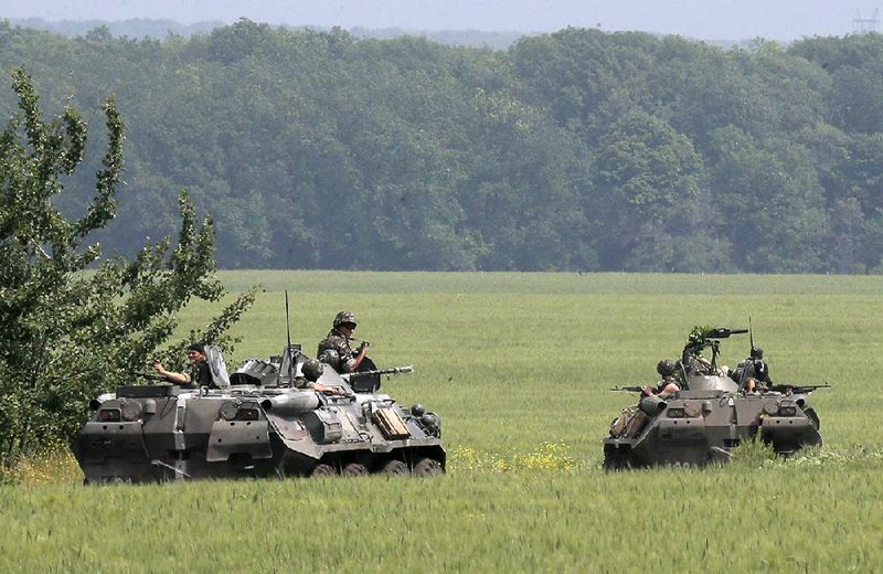 Members of the Ukrainian army inspect an area near Slovyansk, Ukraine, Friday, May 30, 2014. The Ukrainian Acting Defence Minister said on Friday that troops had ousted separatists from southern and western parts of the Donetsk region and north of the Luhansk region. (AP Photo/Efrem Lukatsky)