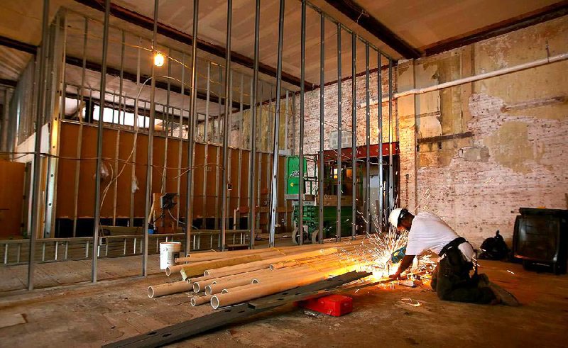 Jason Stubblefield, with Foster Construction, cuts metal pieces on Thursday inside a space that will become a “black-box” theater for Arkansas Repertory Theatre in the Main Street Lofts project in Little Rock. 