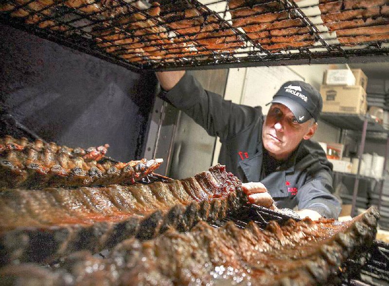 Rich Cosgrove, owner of the Whole Hog Cafe chain, hickory-smokes ribs at his North Little Rock location. He says he is betting on beef and pork prices to fall in coming months. 