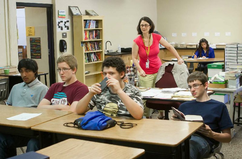 Sharon Lowe, a ninth-grade English teacher, works with her students Friday in her classroom at Darby Junior High School in Fort Smith. Lowe was part of a pilot program for a new teacher-evaluation system that will launch statewide in the fall. 