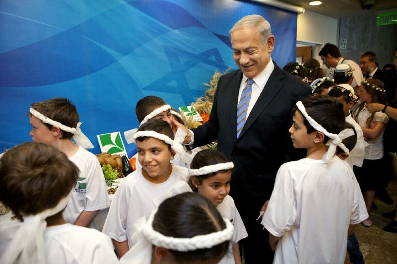 Israeli Prime Minister Benjamin Netanyahu meets children on the Jewish holiday of Shavout, which marks the harvest of the fi rst fruits of the season, before the Cabinet meeting Sunday in Jerusalem. 