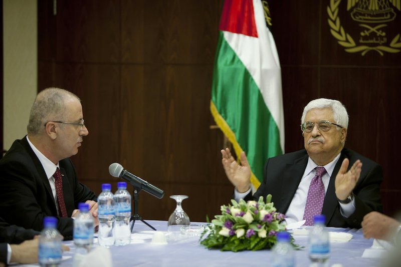 Palestinian President Mahmoud Abbas, right, talks with Palestinian Prime Minister Rami Hamdallah in the West Bank city of Ramallah on Monday, June 2, 2014. 
