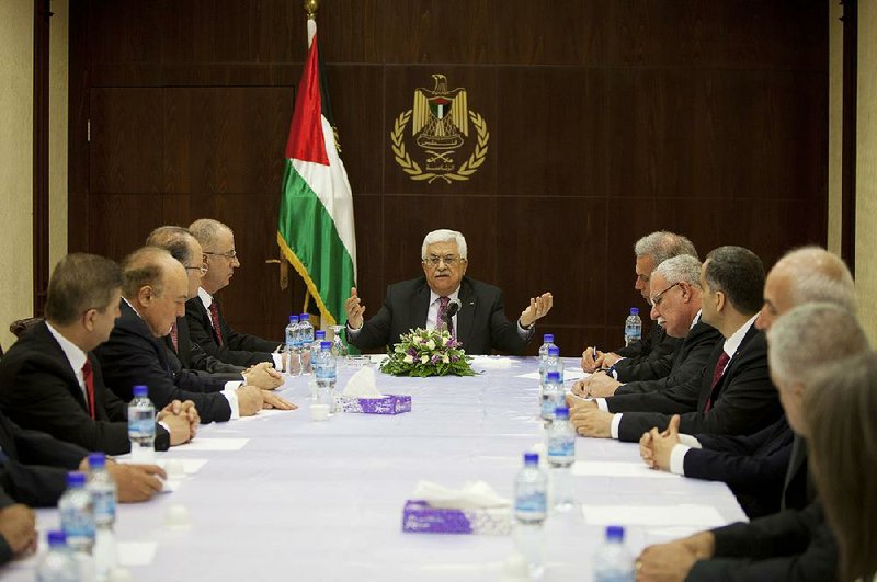 Palestinian President Mahmoud Abbas (center) meets with cabinet members of its unity government, including Prime Minister Rami Hamdallah (center left), in the West Bank city of Ramallah on Monday. 