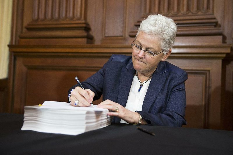 Environmental Protection Agency Administrator Gina McCarthy signs new emission guidelines Monday during an announcement of a plan to cut carbon dioxide emissions from power plants by 30 percent by 2030. 