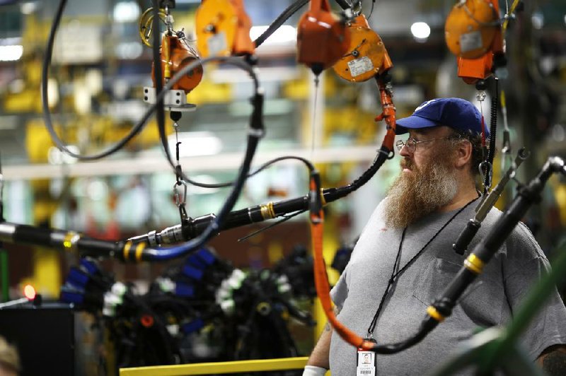 A Cummins Inc. employee works on a diesel truck engine assembly line at the Cummins Mid-Range Engine Plant in Columbus, Ind., on Monday. Orders to U.S. factories rose for a third consecutive month in April, the Commerce Department said Tuesday.