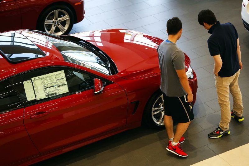 Shoppers look at a 2014 BMW AG 428i coupe displayed at a dealership in Santa Ana, Calif., on Monday. U.S. auto sales rose 11 percent in May, the highest monthly total since July 2005.