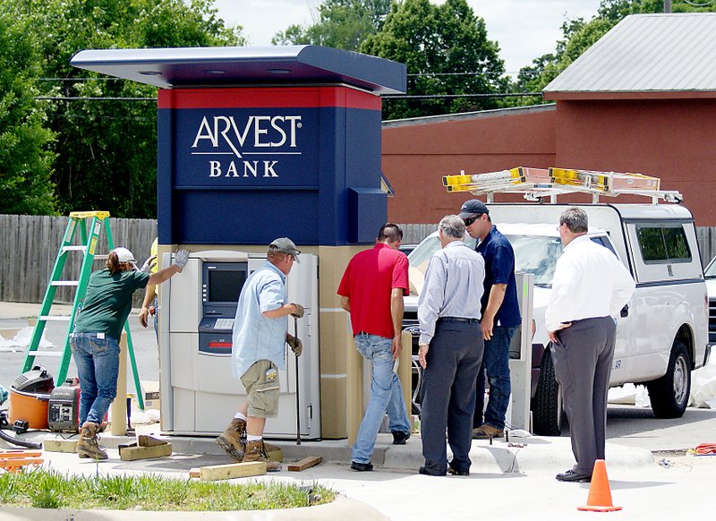 Photo by Randy Moll Workers installed a new ATM for Arvest Bank on Thursday. The new ATM was expected to be up and running soon, with a ribbon cutting set for Monday, June 9.