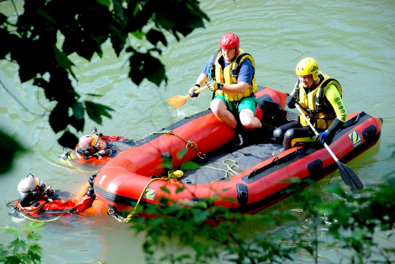 Photo by Jeff Della Rosa Benton County Dive Team members work on the Illinois River on Saturday searching for the body of Timothy Clements, 18, of Gentry. Clements drowned Friday evening during a fishing trip.