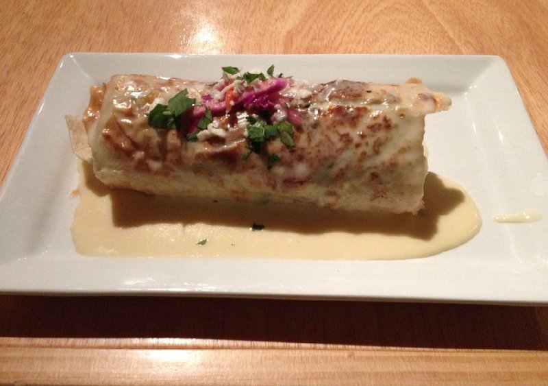 A Cuban Burrito of shredded pork is topped with cheese sauce at Baja Grill in Little Rock.