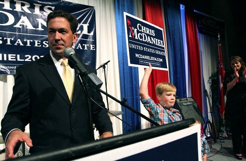 Chris McDaniel addresses supporters as his son Cambridge, 7, joins him on the stage late Tuesday in Hattiesburg, Miss. McDaniel holds a slight edge over U.S. Sen. Thad Cochran in the vote tally. 