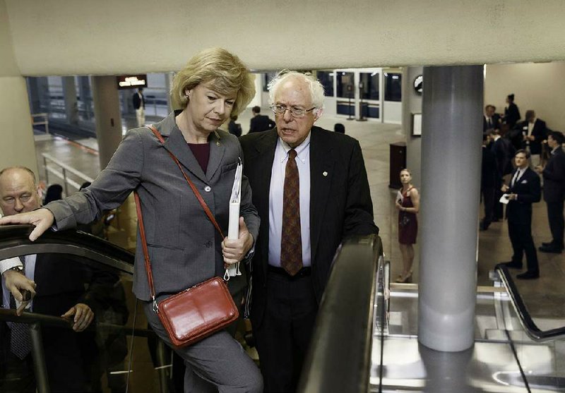 Bernie Sanders, I-Vt., chairman of the Senate Veterans Affairs Committee, chats with Sen. Tammy Baldwin, D-Wis., as they take an escalator Wednesday to the Senate chamber. Sanders is negotiating an accord to expand authority to fire Veterans Affairs Department officials. 
