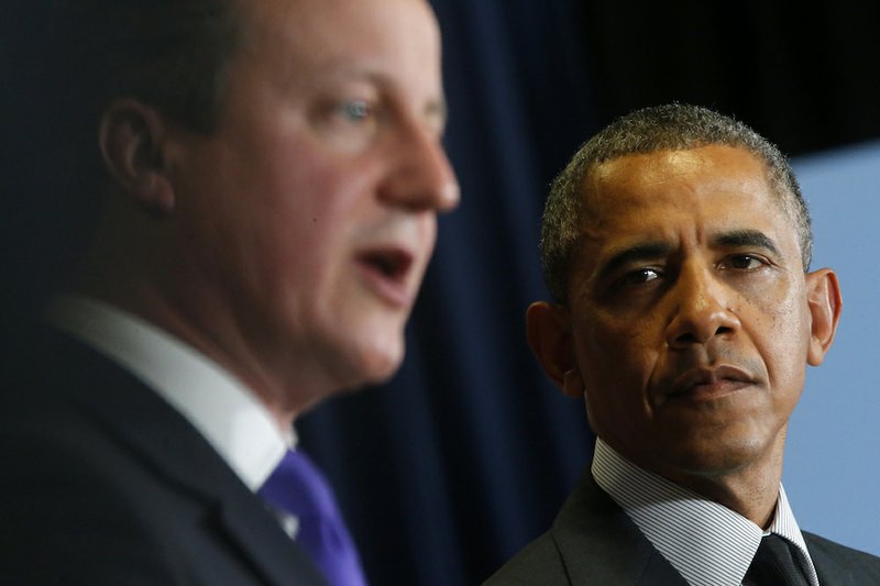 President Barack Obama listens as British Prime Minister David Cameron speaks during a news conference at the G7 summit in Brussels, Belgium, on Thursday, June 5, 2014. 
