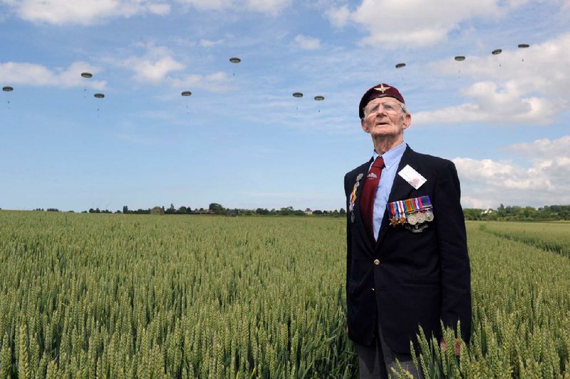 British World War II veteran Frederick Glover watches Thursday as soldiers parachute down during a D-Day commemoration event in Ranville, western France, on the eve of the 70th anniversary of the World War II Allied landings in Normandy. 
