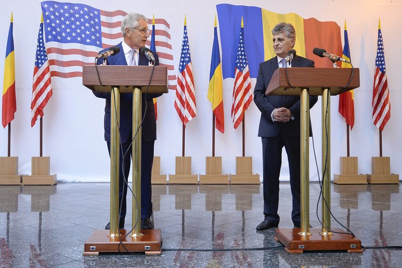 US Secretary of Defense Chuck Hagel listens to Romanian Defense Minister Mircea Dusa's speech during a joint press statement that followed their visit of the USS Vella Gulf, in Constanta, Romania, Thursday, June 5, 2014.