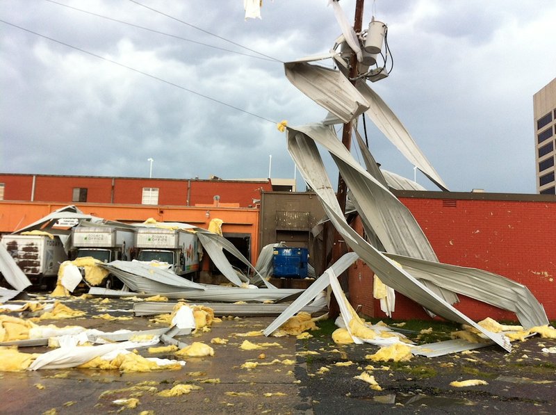 Debris is strewn around a building and power pole on 8th Street between Gaines and State streets in Little Rock after powerful thunderstorms tore through central Arkansas on Friday, June 6, 2014.