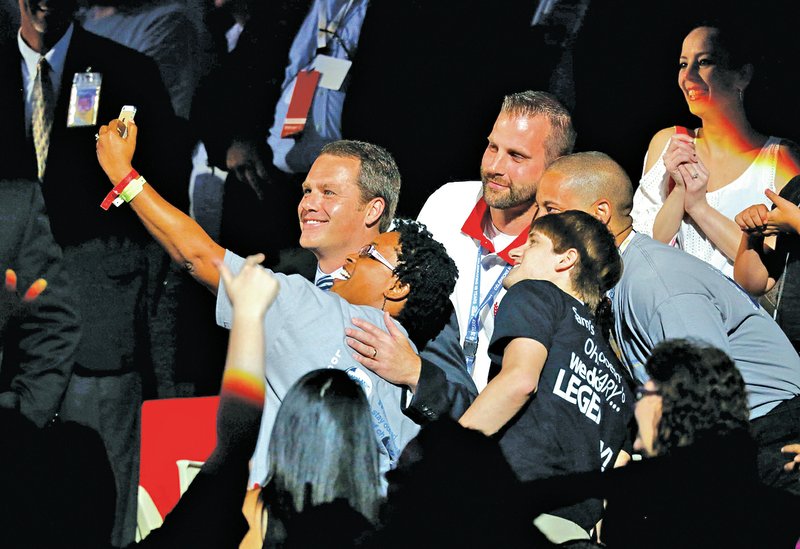 STAFF PHOTO JASON IVESTER Doug McMillon, Walmart chief executive officer, takes a selfie with employees in the crowd Friday during the annual Shareholders Meeting at Bud Walton Arena in Fayetteville.