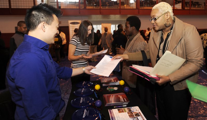 AP/DAVID COATES - A Quicken Loans recruiter (left) talks with a job seeker at a Detroit job fair in April. U.S. employers have added more than 200,000 jobs a month for four straight months, the Labor Department said Friday.